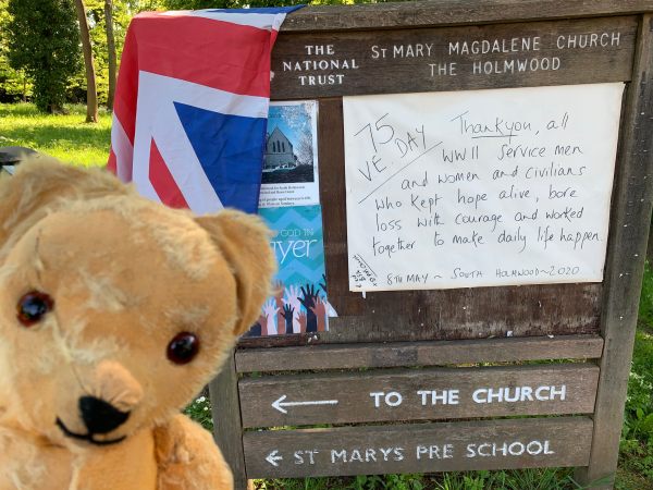 Eamonn by the National Trust / St Mary Magdelen Church Holmwood noticeboard, with notices about the VE Day celebrations.