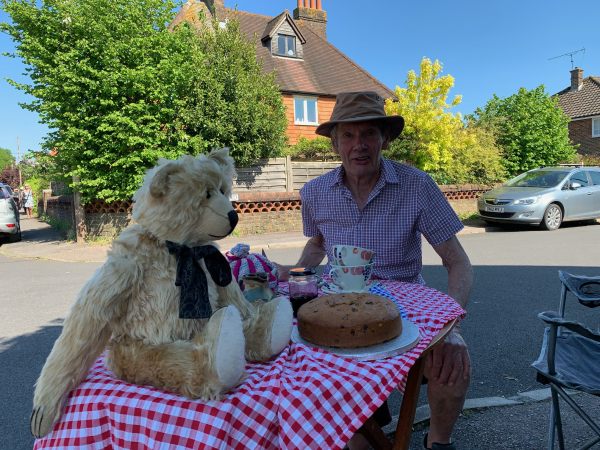 Bertie now sat on the table which is now open. A spread of food, including a massive cake, in on it. Mike is also sat at the table.