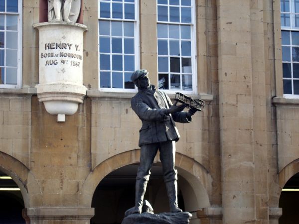 Bronze statue of Charles Rolls in Monmouth. He is holding a model aeroplane.