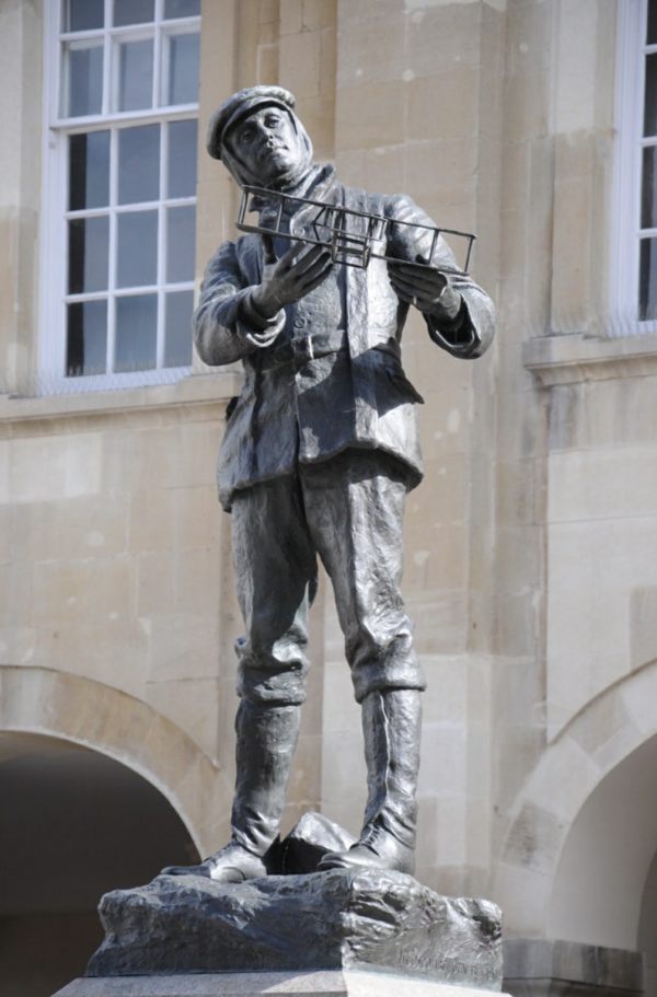 Bronze statue of Charles Rolls in Monmouth. He is holding a model aeroplane.