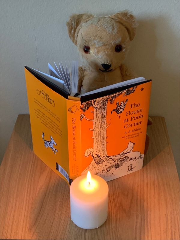 Eamonn reading "The House at Pooh Corner" by AA Milne, with a candle lit for Diddley.