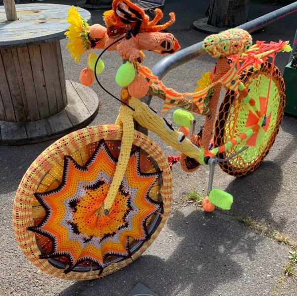 Yarnbomb Sisters - knitted bicycle, mainly yellows and browns.