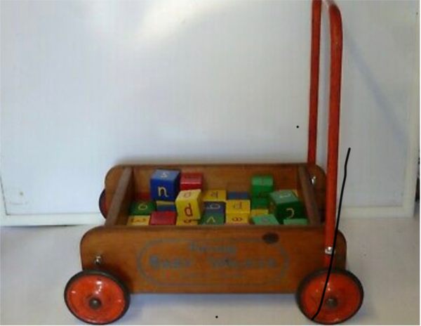 An old fashioned wooden baby walker.