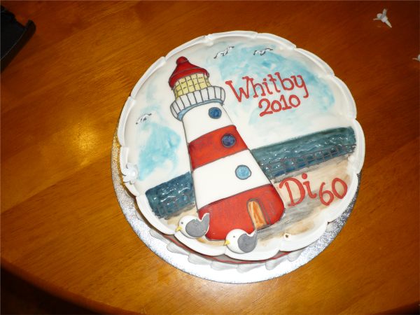Birthday Cake. Lighthouse and sea. "Whitby 2010" and "Di 60".