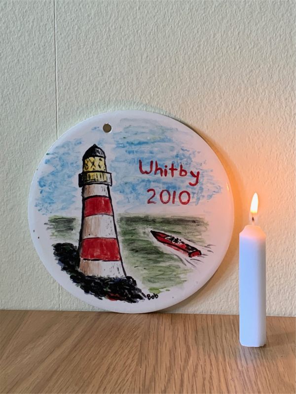 And here is that plaque painted on a rainy day in Whitby ten years ago, behind a candle lit for Diddley.