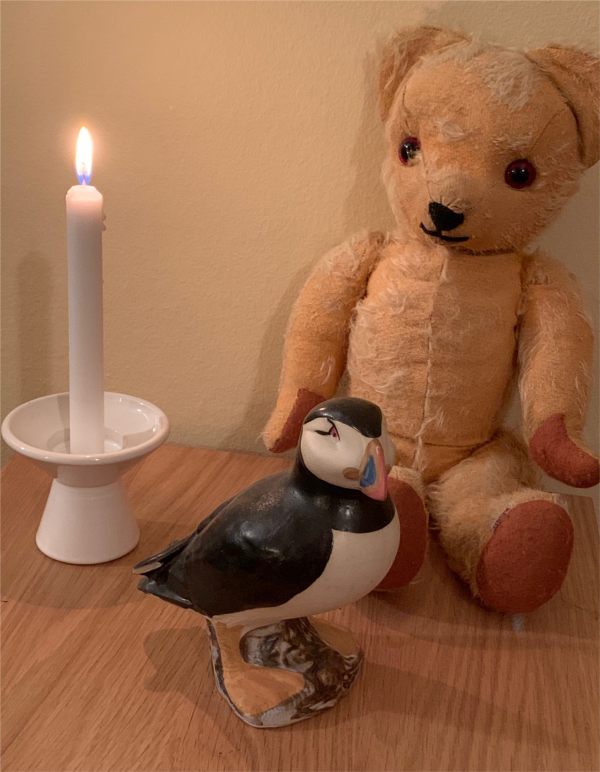 Eamonn, a china Puffin ornament and a candle lit for Diddley.