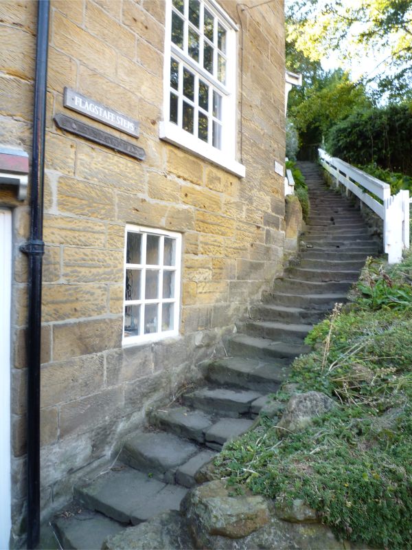 Steep steps of the Cleveland Way up the side of a stone built house.