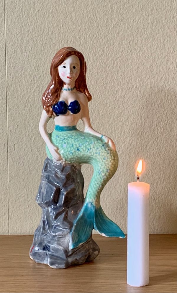 The repaired mermaid and a candle lit for Diddley.