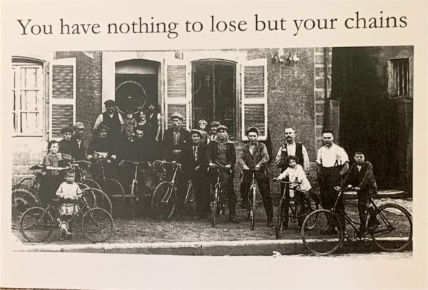 Old Black & White newspaper photograph of several men on their pedal bikes outside a row a terraced houses facing straight onto the pavement. Caption above reads "You have nothing to lose but your chains."