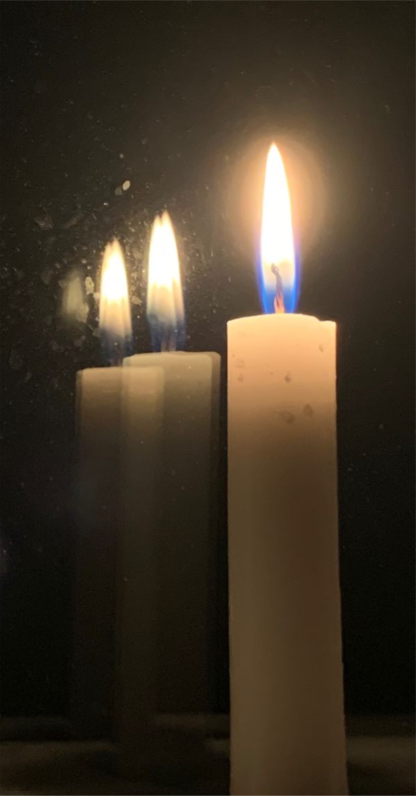 A candle lit for Diddley, reflected in a mirror.
