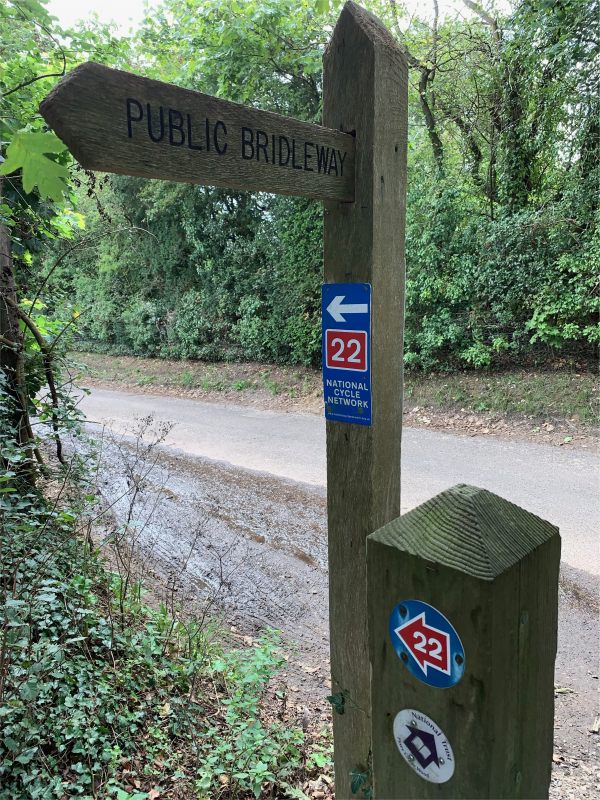 Signpost for a Public Bridleway, with more waymarker signs on it.