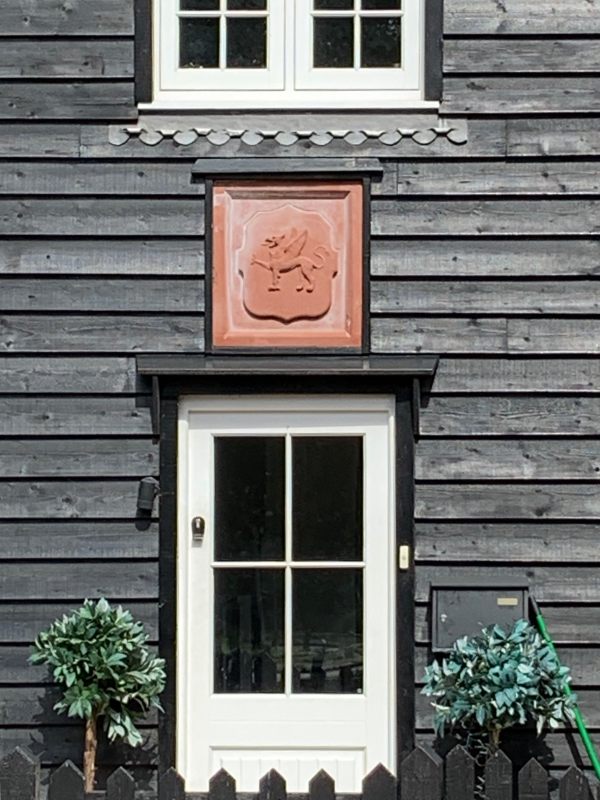 Griffon above a door on a wooden building.