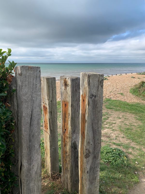 Old railway sleepers standing vertically as fence posts.