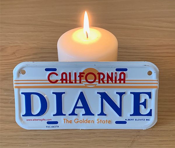 A candle lit for Diddley, with a Californian licence plate "Diane" in front. A reminder of the trip to Capistrano.