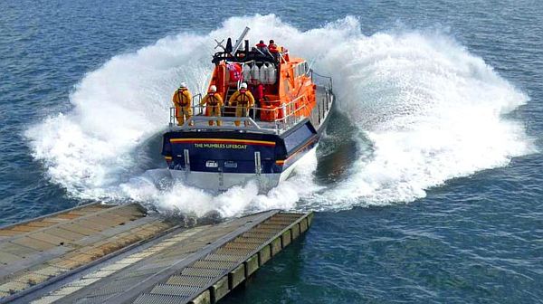 Mumbles lifeboat "Roy Barker IV" splashing into the sea at the end of the slipway.