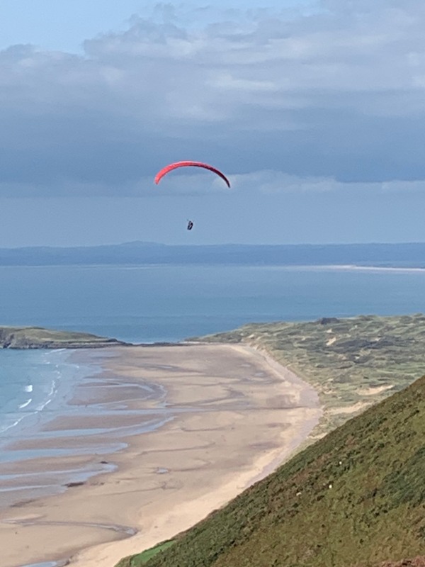 A kitesurfer over Rhossili Down and beach looking north over Llanelli Bay.