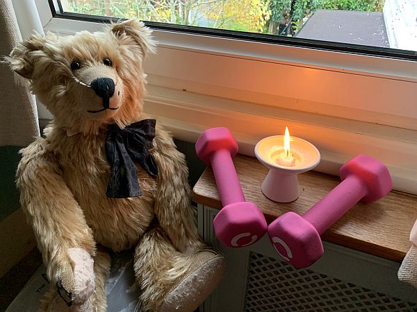 Bertie by the window with a candle lit for Diddley and two pink dumbells either side.