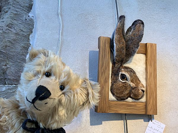 Bertie and the framed picture of a hare. The ears are coming up above the top of the frame.