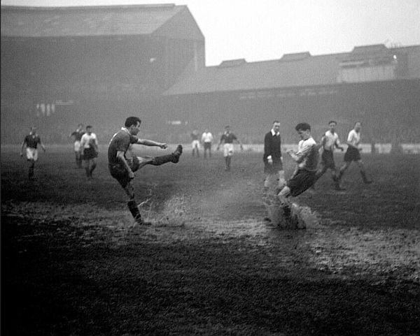 Black and white photograph of Chelsea playing on a soggy, muddy pitch.