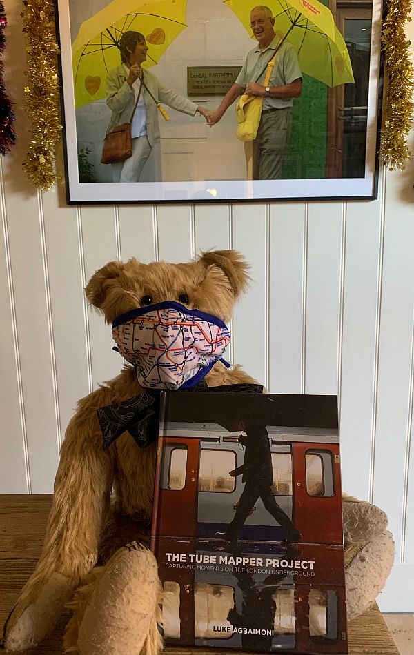 Bertie wearing an Underground map face mask and showing off the "Tube Mapper Project" book.