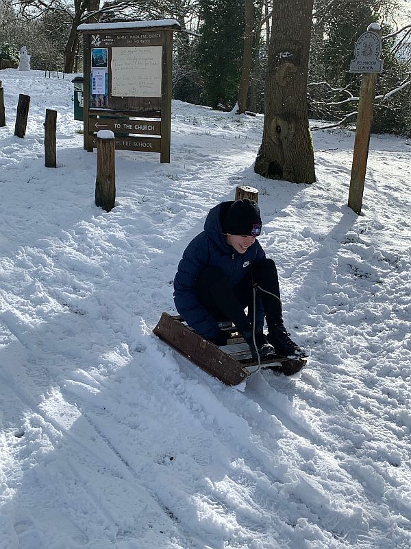 Daisy-Mae sledging down a snowy hill.