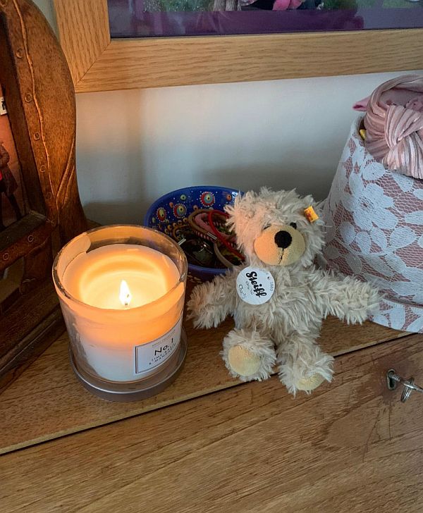 A Candle lit for Diddley with a little Steiff Bear alongsige.