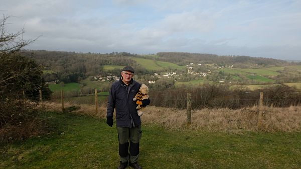 Bobby walking along a path carrying Bertie.