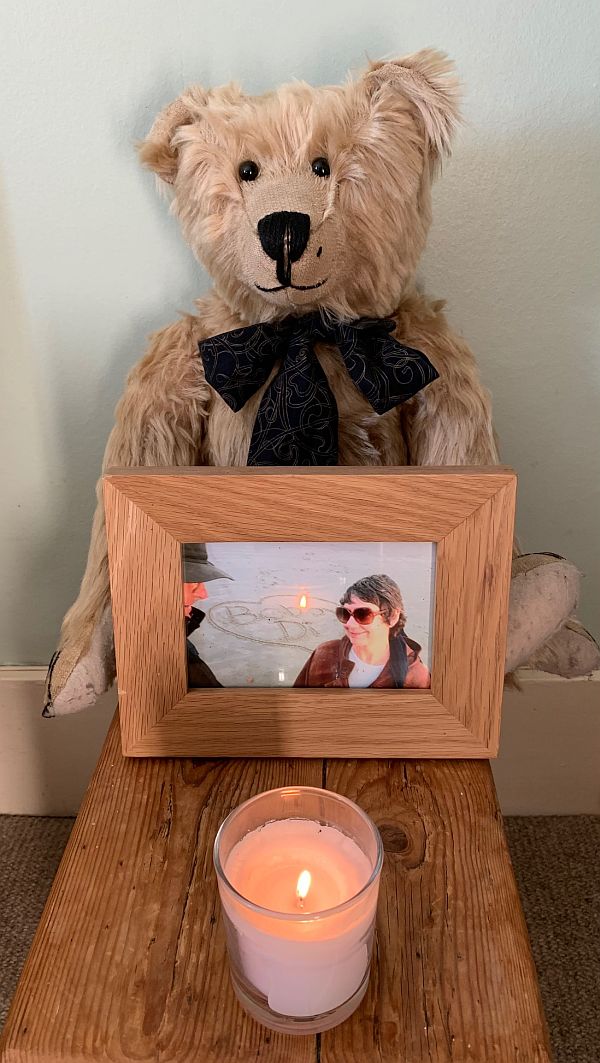 Bertie holding a picture of Bobby & Diddley with a candle in front.