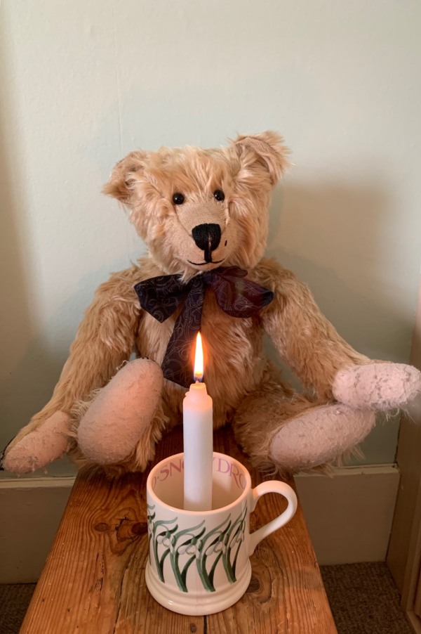 Bertie sat behind a candle lit for Diddley in a mug.