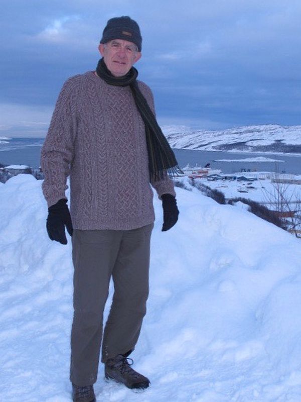 Bobby wearing the fawn Aran jumper on a snow capped mountain in Norway.