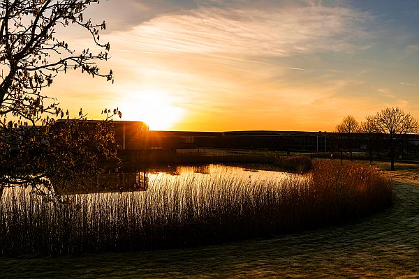 View of the Rolls-Royce plant across the lake looking into the rich colours of the sunset.