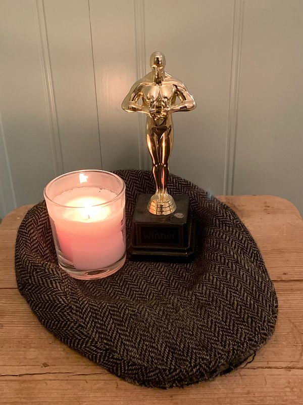 A candle lit for Diddley alongside an Oscar replica on Bobby's favourite cap.