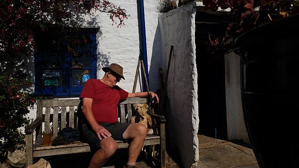 Bobby and Bertie sat on a wooden bench outside the Square & Compass, Worth Matravers.