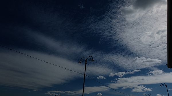 Beautiful white cloud-speckled sky and streetlight.