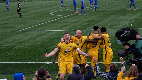 Players celebrating their second goal.