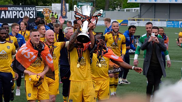 Team doing the lap of honour with the trophy.