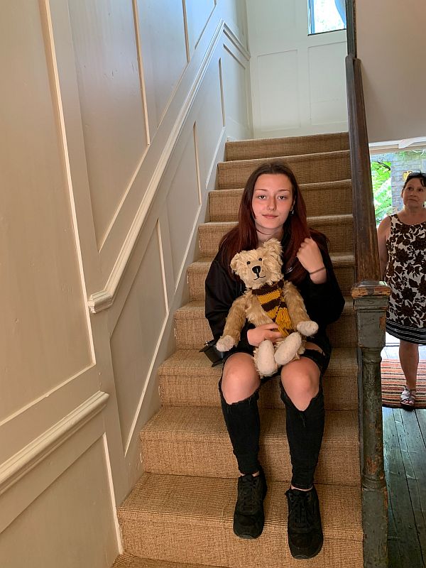 Amber sat on the stairs with Bertie. Ann is in the background.