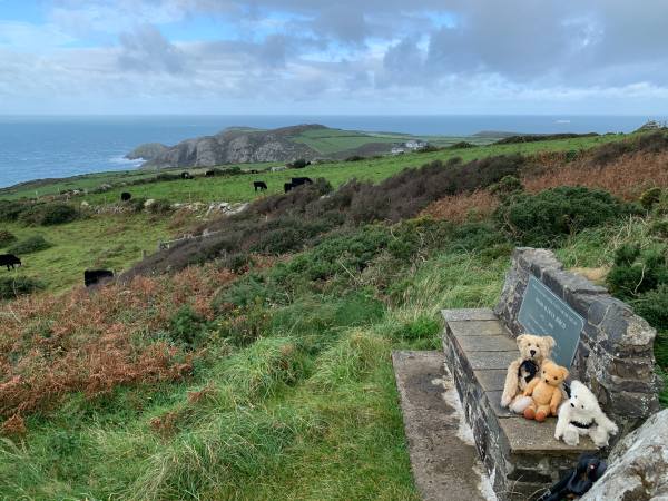 Bertie, Eamonn & Trevor sat on a bench, with the view and the sea behind.