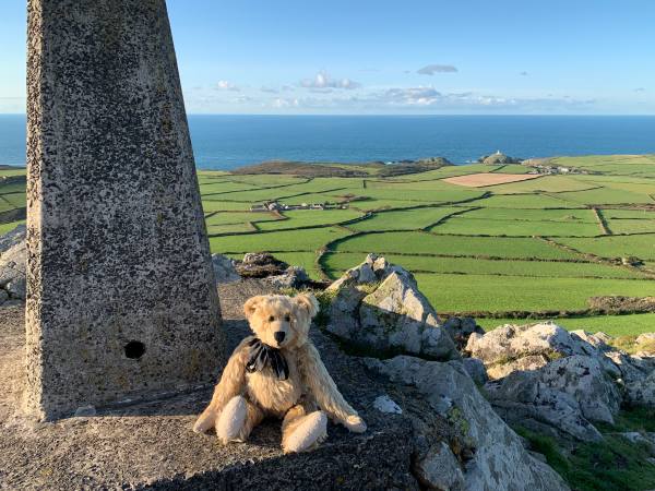 Bertie sat by the Trig Point on top of Garn Fawr, with the ssea in the distance behind.