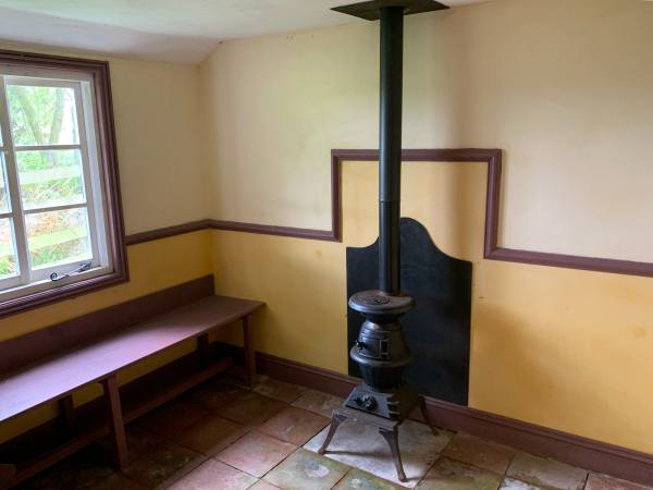 Pot-bellied stove inside the tiled and simply painted Goose House.