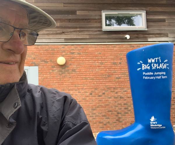 Bobby looking at a blue welly labelled "WWT's Big Splash Puddle Jumping February Half Term.