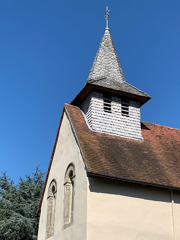 The short bell tower and spire of Wisley Church.