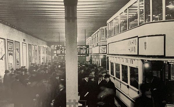 A white double-deck tram at a crowded Holborn tram stop in the Kingsway Tunnel for the special occassion of the opening of the new southern tunnel entrance.