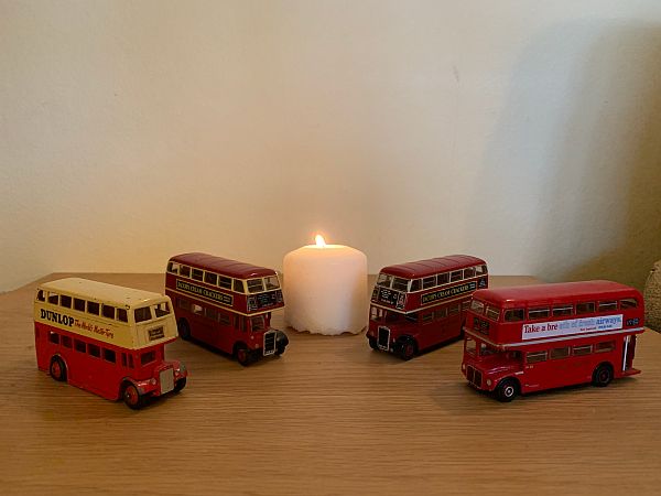 A candle lit for Diddley in the midst of 4 of Bobby's model buses.