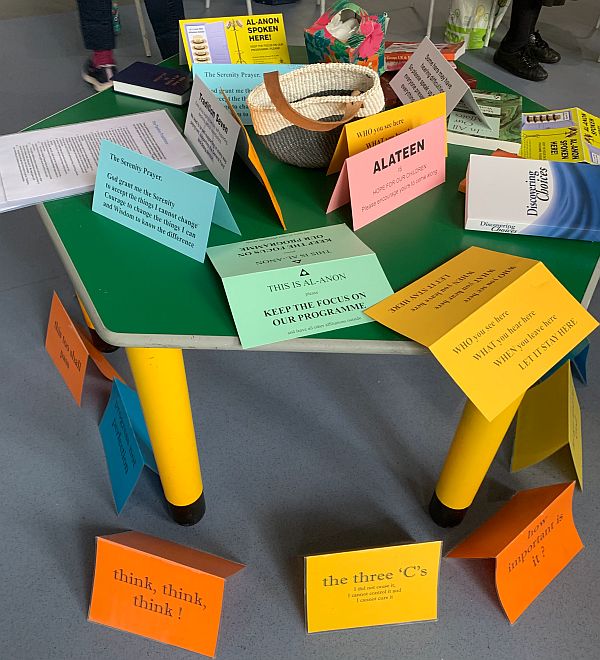 A table at an Al-Anon meeting showing a number of cards with short thoughts on them.