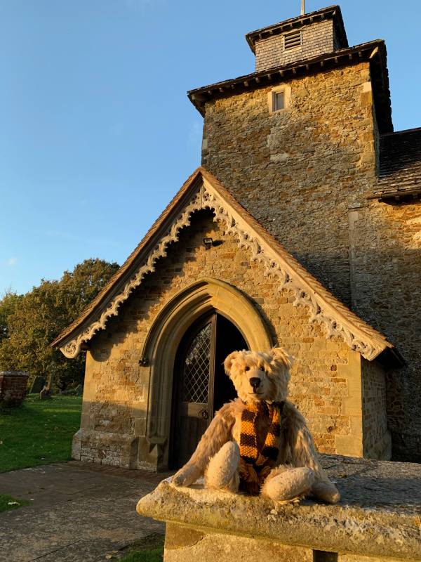 Bertie sat on the wall outside St John the Evangelist, Wotton, with a glorious blue sky background.