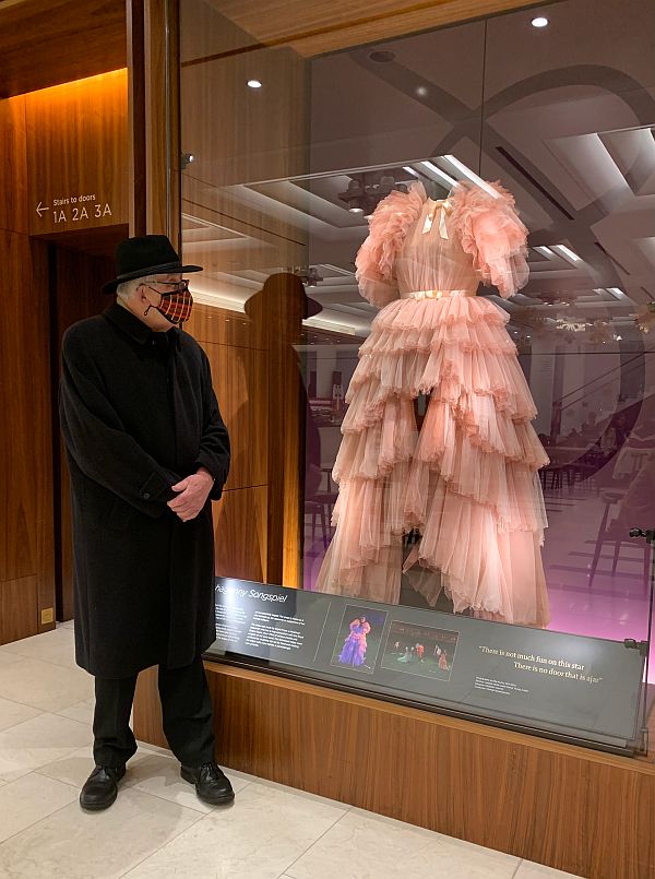 Bobby admiring a dress in a glass case.