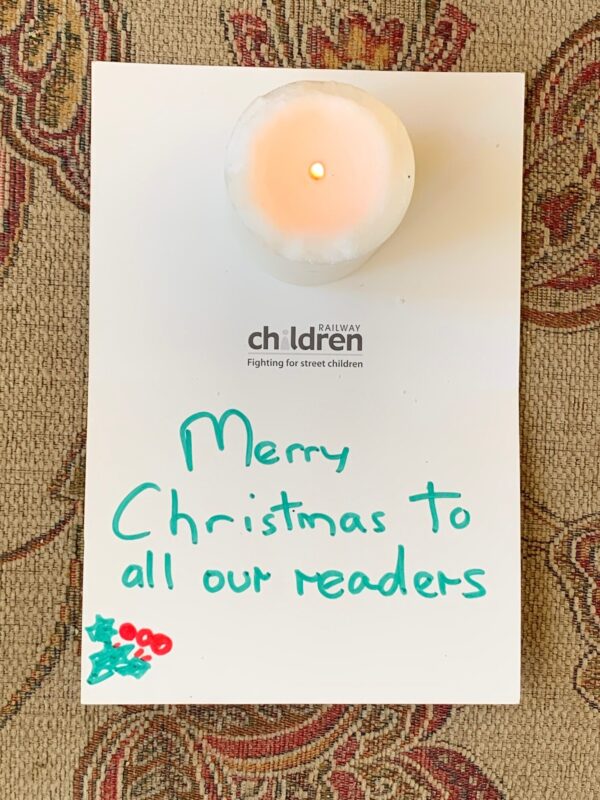 The inside of a Railway Children card signed "Merry Christmas to all our Readers, with a candle lit for Diddley.