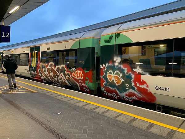 Two coaches of a Southern Railway train covered in graffiti. Service cancelled due to an incident.