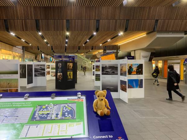 The "Landscape Photographer of the Year" exhibition at London Bridge Station, with Eamonn sat on a panel.